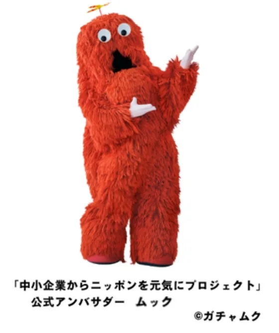 赤い毛むくじゃらのキャラクター「ムック」が、両手を広げて立っている様子を描いた画像です。