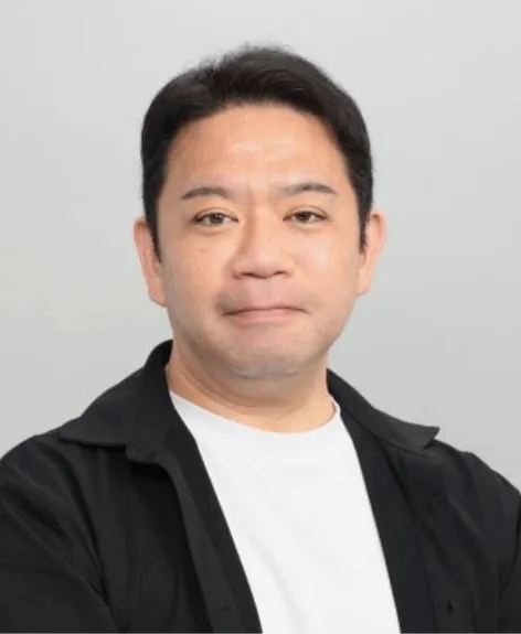 正面を向いた男性のポートレート。彼は黒いシャツと白いTシャツを着ています。背景は白。