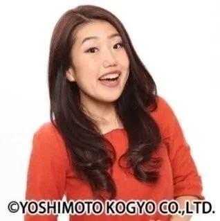 オレンジ色のトップスを着た女性のポートレート写真です。