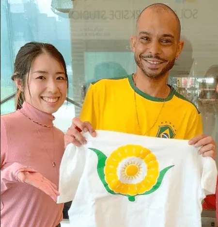 ブラジルの国旗のマークが描かれたTシャツを持つ2人の人々