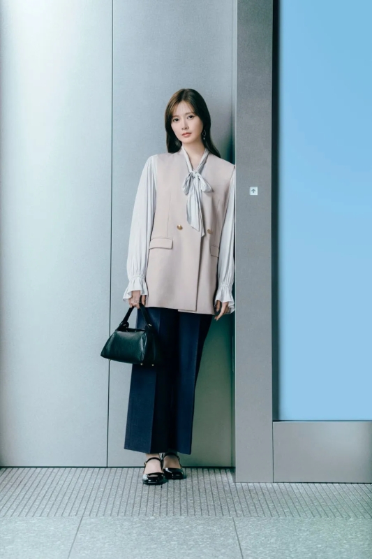 エレベーターのドアの前に立つ女性の着用イメージ