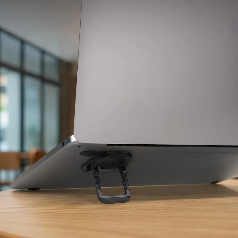 ノートパソコンの下に設置されたスタンドのクローズアップ写真。スタンドはノートパソコンを持ち上げ、画面の角度を調整するために使用されます。