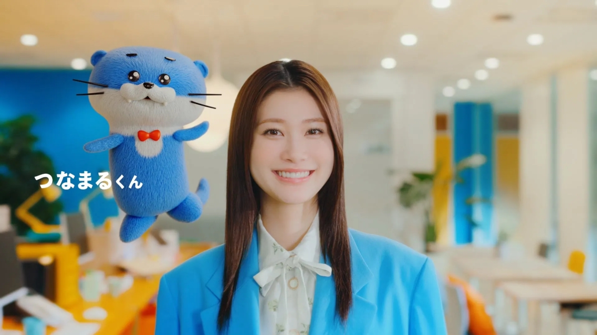 女性と青いアザラシのようなキャラクター「つなまるくん」が一緒に写っている画像
